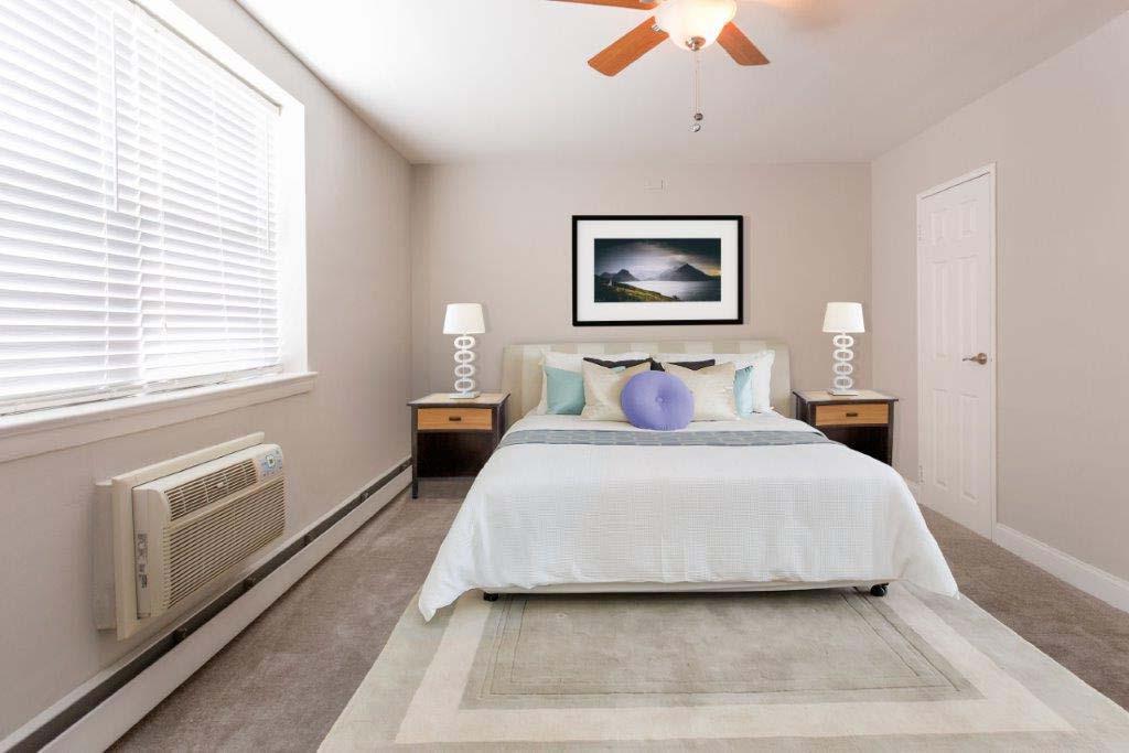 Fully furnished bedroom with a ceiling fan and open window at Willow Bend apartments for rent